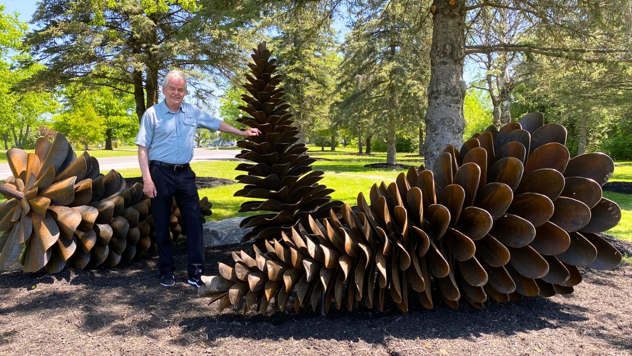 Image of Dr Leo Groarke with the new Pinecones Sculpture at Trent Symons Campus