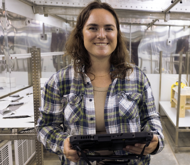 A woman smiling holding a tablet