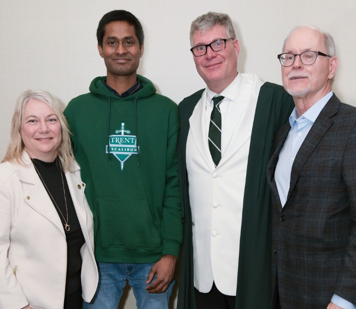 Dr. Cathy Bruce taking a picture with 3 guys