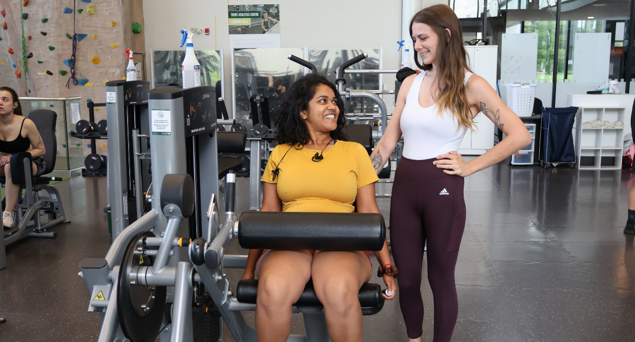 2 girls smiling at each other at the gym