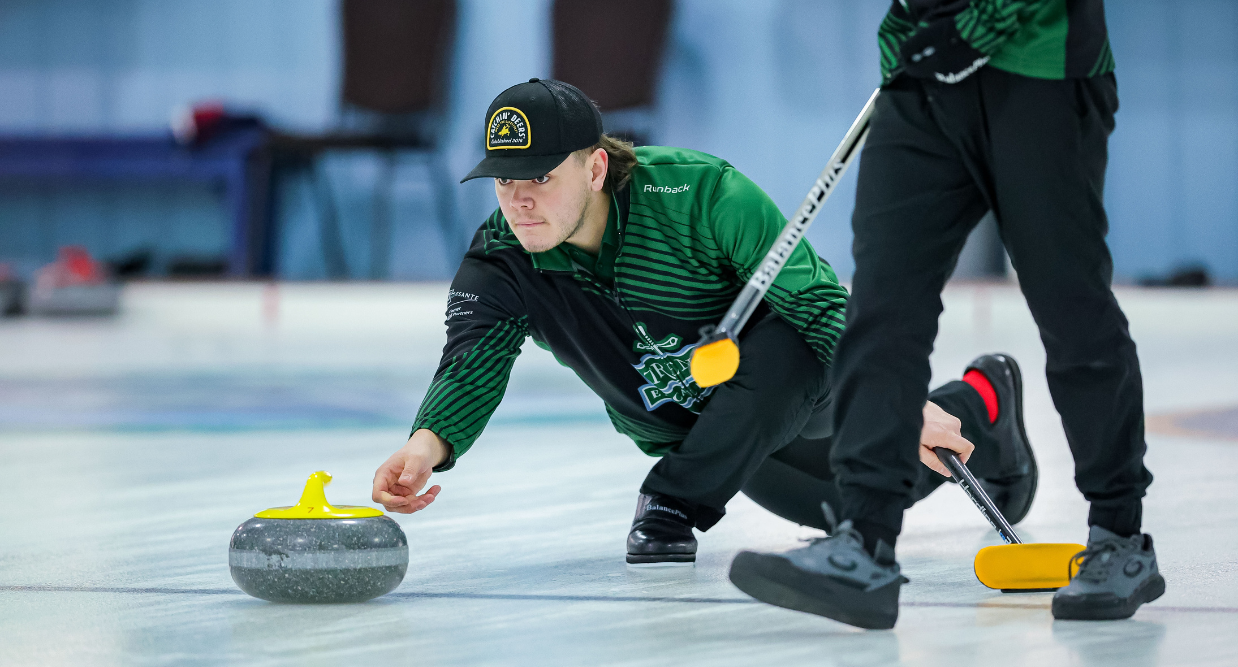 A guy playing curling